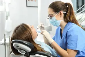 A dentist performs a tooth cleaning for a patient