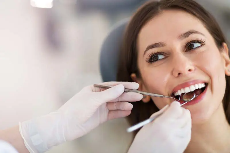 Young woman in dentist office receiving dental care from dental hygienist
