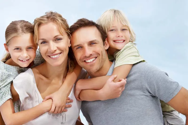 Young couple with children smiling at the camera